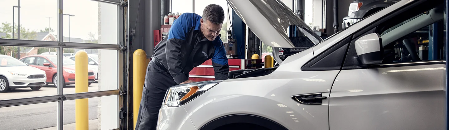 Ford Service Tech working under a hood