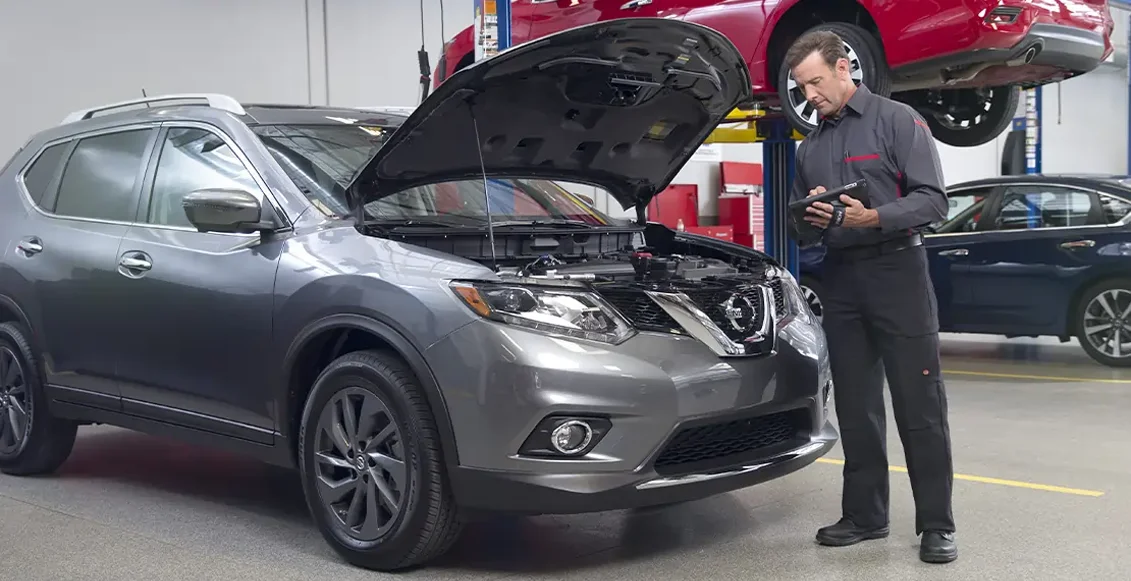 Nissan Tech Looking Over Vehicle