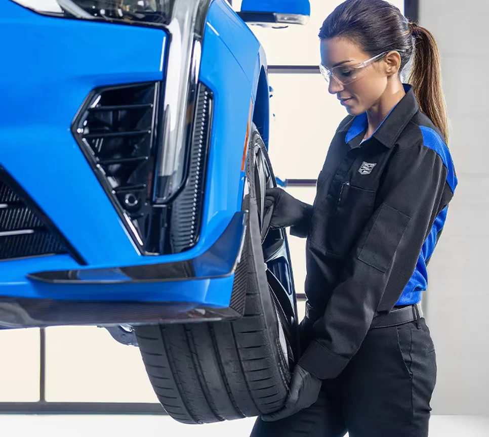 Cadillac service tech looking at tire