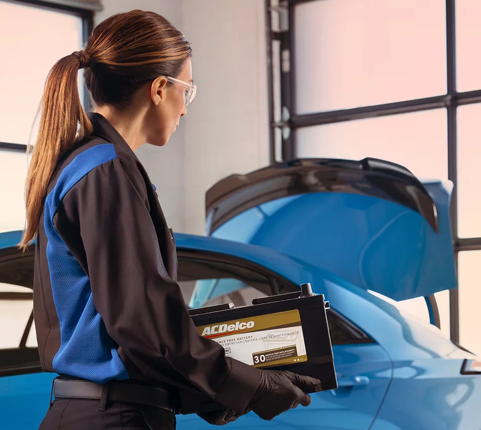 Cadillac service tech holding a battery