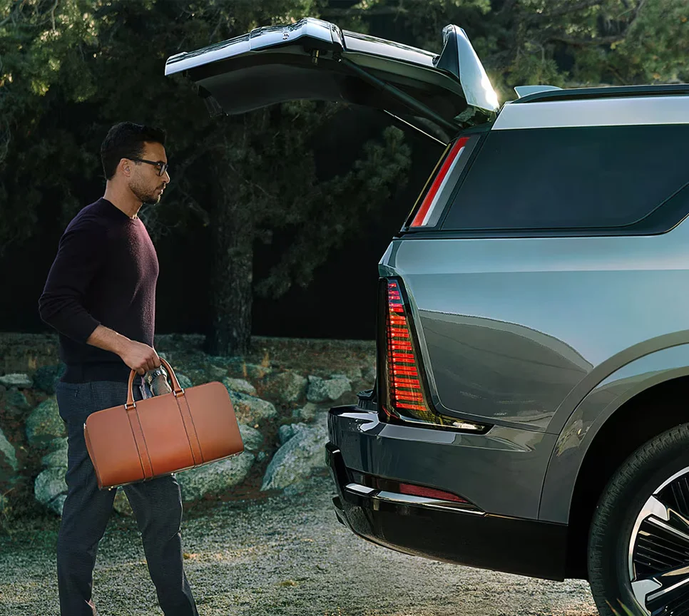 Man putting a bag in the back of a Cadillac