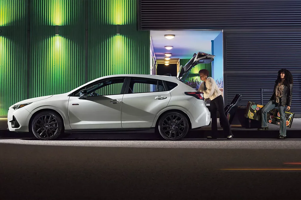 People Loading Instruments Into Trunk of Subaru Impreza