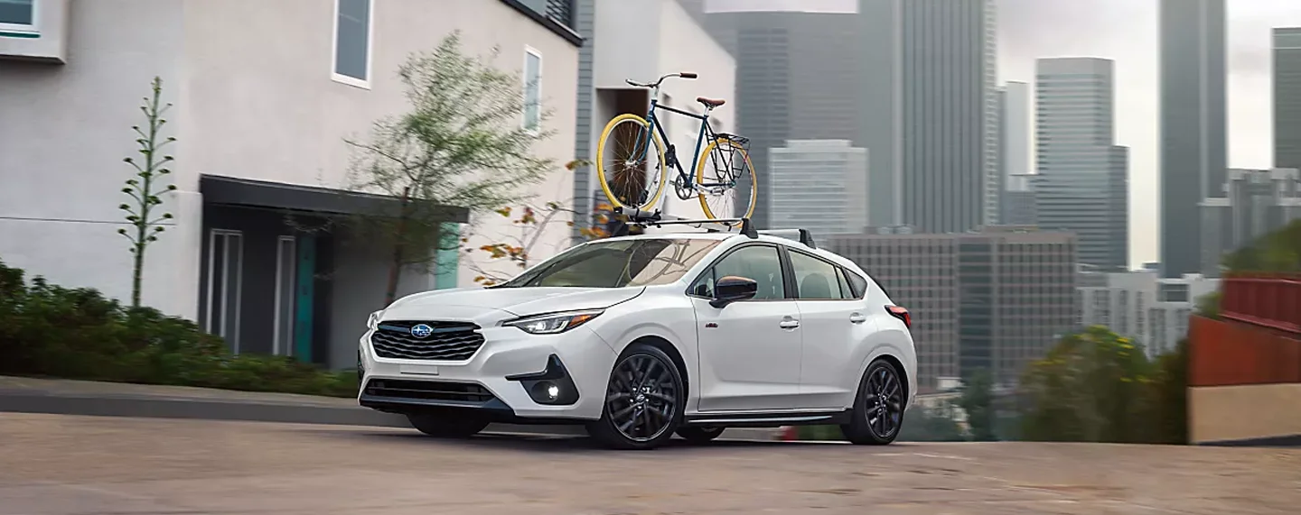 Subaru Driving Down City Road