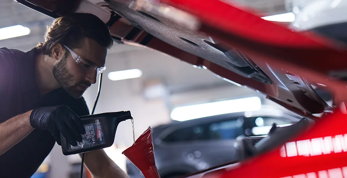Mazda Tech working under a hood