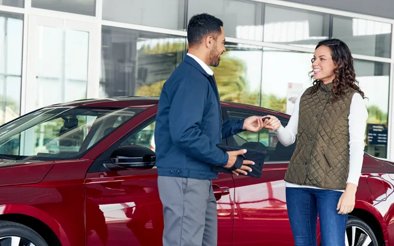 Woman being handed a car key