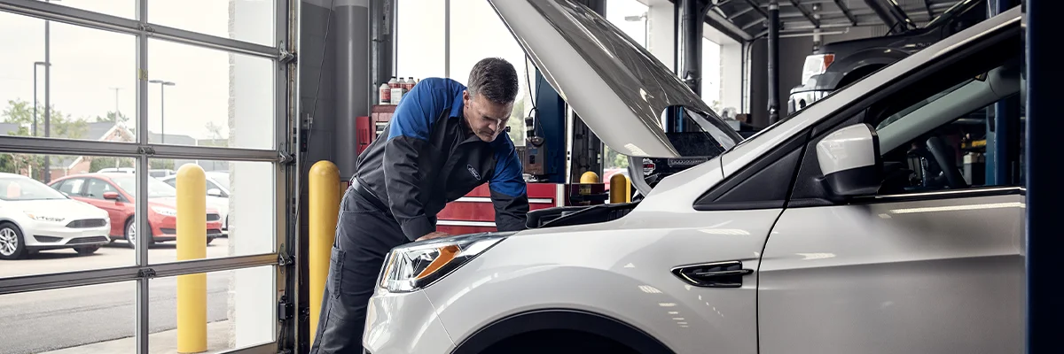 Ford Service Tech working under a hood