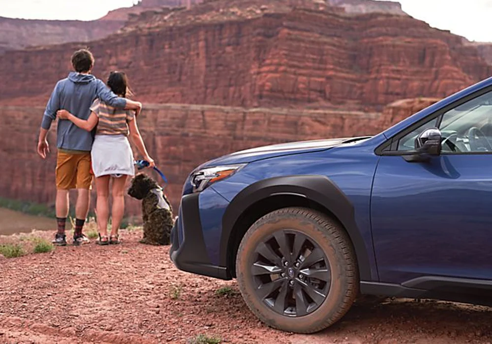 Couple and Dog Standing Near Subaru